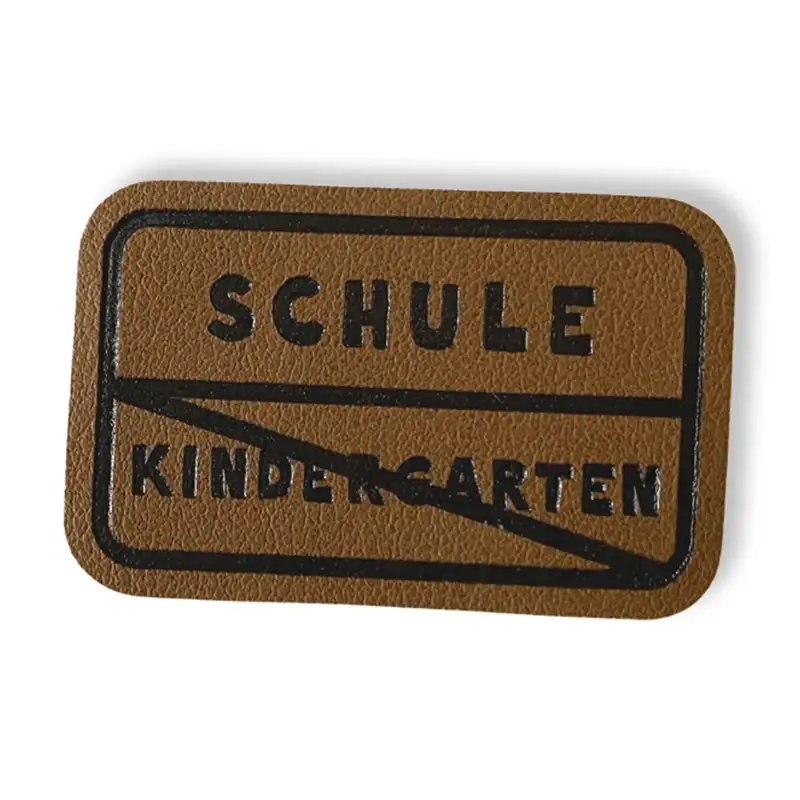 Lederlabel Schriftzug Schule und Kindergarten durchgestrichen